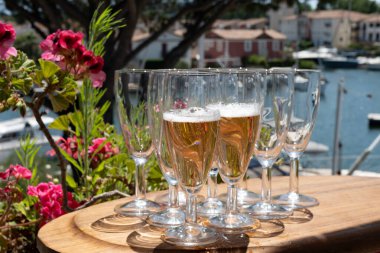 Fransız brut şampanyası şampanya köpüklü lale kadehleri ile Saint-Tropez yakınlarındaki Port Grimaud limanında, Fransız Riviera tatili, Var, Fransa yaz tatili