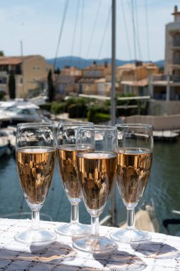 Fransız brut şampanyası şampanya köpüklü lale kadehleri ile Saint-Tropez yakınlarındaki Port Grimaud limanında, Fransız Riviera tatili, Var, Fransa yaz tatili