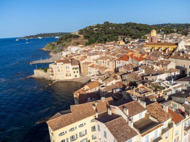 Aerial view on bays, beaches, old colorful houses of famous Saint-Tropez town on French Riviera at sunset, Var, Provence, France, summer vacation destination clipart