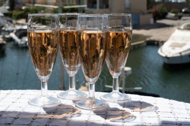 Fransız brut şampanyası şampanya köpüklü lale kadehleri ile Saint-Tropez yakınlarındaki Port Grimaud limanında, Fransız Riviera tatili, Var, Fransa yaz tatili