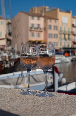 Saint-Tropez 'de eski balıkçı tekneleri limanı ve yat limanında soğuk Fransız gülü Cote de Provence şarabı, Fransa' nın Provence şehrinde yaz tatili