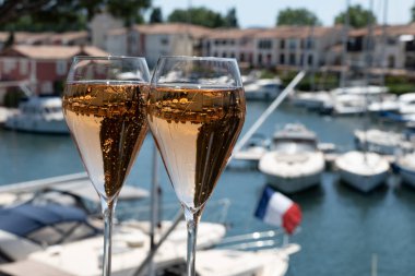 French brut rose champagne sparkling wine in tulip glasses in yacht harbour of Port Grimaud near Saint-Tropez, French Riviera vacation, Var, France is summer clipart