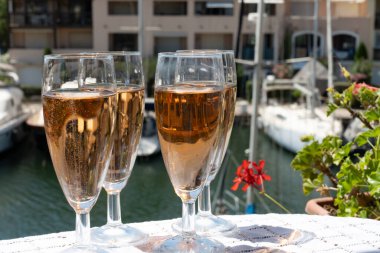 Fransız brut şampanyası şampanya köpüklü lale kadehleri ile Saint-Tropez yakınlarındaki Port Grimaud limanında, Fransız Riviera tatili, Var, Fransa yaz tatili