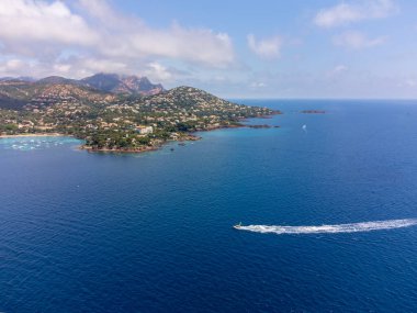 Mavi Akdeniz 'deki panoramik manzara, Agay kasabasının kumlu plajı, Esterel kızıl dağları yakınlarındaki yaz tatili merkezi, Fransız Riviera, Provence. Fransa