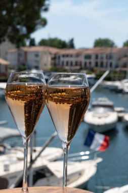 Fransız brut şampanyası şampanya köpüklü lale kadehleri ile Saint-Tropez yakınlarındaki Port Grimaud limanında, Fransız Riviera tatili, Var, Fransa yaz tatili