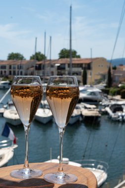Fransız brut şampanyası şampanya köpüklü lale kadehleri ile Saint-Tropez yakınlarındaki Port Grimaud limanında, Fransız Riviera tatili, Var, Fransa yaz tatili