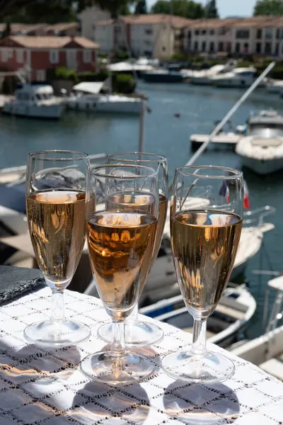 stock image French brut rose champagne sparkling wine in tulip glasses in yacht harbour of Port Grimaud near Saint-Tropez, French Riviera vacation, Var, France is summer