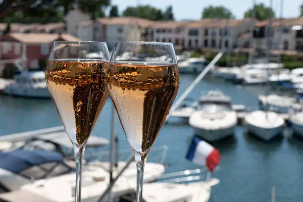 stock image French brut rose champagne sparkling wine in tulip glasses in yacht harbour of Port Grimaud near Saint-Tropez, French Riviera vacation, Var, France is summer