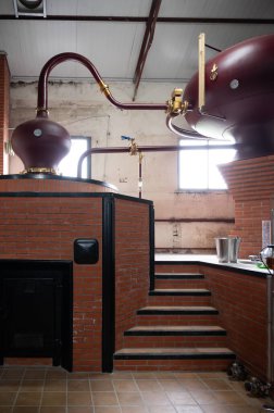 Double distillation process of cognac spirits in Charentias copper alambic still pots and boilers in old distillery in Cognac white wine region, Charente, Segonzac, Grand Champagne, France clipart