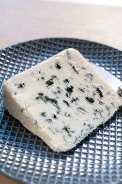 Piece of French blue cheese Roquefort, made from sheep milk in caves of Roquefort-sur-Soulzon, France clipart