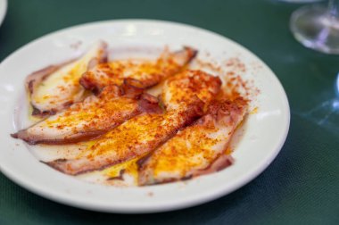 Geleneksel Endülüs yemeği pulpo ahtapot deniz ürünleri eski tavernada tapa olarak kırmızı pimento paprika ile servis edilir, Sanlucar de Barrameda, İspanya