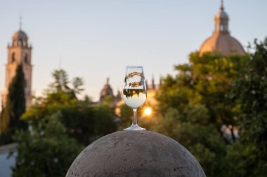 Sherry wine glasses and old bogedas jerez wine cellars and church on background in Jerez de la Frontera, wine glasses served outdoor, cityview, Andalusia, Spain clipart