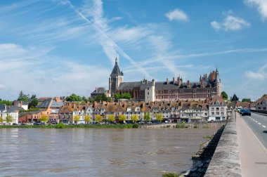 Loire nehri kıyısındaki Gien kasabasının eski bir kısmının manzarası, Loiret departmanı, Fransa, kiremit çatılı evler ve bacalar, kale ve köprü.