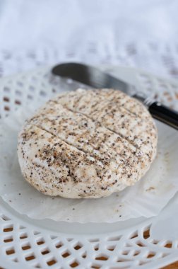 Fransız taze beyaz keçi peynirleri üzerine karabiber katılmış, yakın plan.