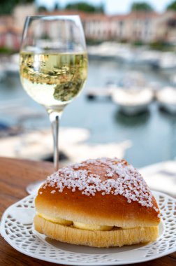 Fransız Rivierası 'nın şarap ve kekleri, bir bardak soğuk beyaz Cote de Provence şarabı ve Port Grimaud limanında Tarte Tropezienne keki, Fransa' nın Provence şehrinde yaz tatili