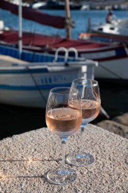 Saint-Tropez 'de eski balıkçı tekneleri limanı ve yat limanında soğuk Fransız gülü Cote de Provence şarabı, Fransa' nın Provence şehrinde yaz tatili