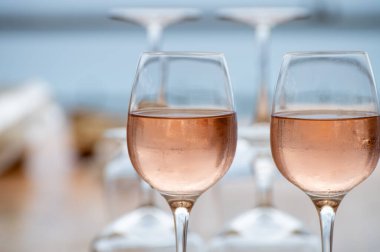 Provence 'de yaz mevsimi, arka planda mavi deniz manzaralı iki bardak soğuk gül şarabı, Fransa' nın güneyinde Menton ve Monako yakınlarında Fransız Rivierası.