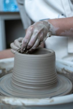 Polonya 'da modern sanat seramik atölyesinde atölye çalışması sırasında çömlekçi çarkında çamur tenceresi yapmak