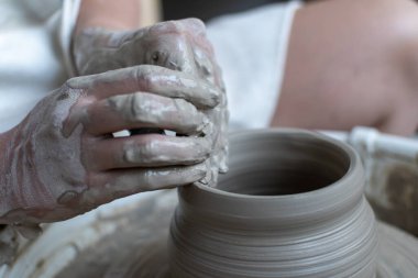 Polonya 'da modern sanat seramik atölyesinde atölye çalışması sırasında çömlekçi çarkında çamur tenceresi yapmak