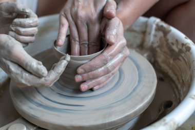 Polonya 'da modern sanat seramik atölyesinde atölye çalışması sırasında çömlekçi çarkında çamur tenceresi yapmak