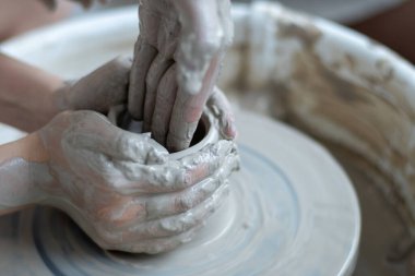 Polonya 'da modern sanat seramik atölyesinde atölye çalışması sırasında çömlekçi çarkında çamur tenceresi yapmak