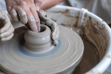 Polonya 'da modern sanat seramik atölyesinde atölye çalışması sırasında çömlekçi çarkında çamur tenceresi yapmak