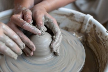 Polonya 'da modern sanat seramik atölyesinde atölye çalışması sırasında çömlekçi çarkında çamur tenceresi yapmak