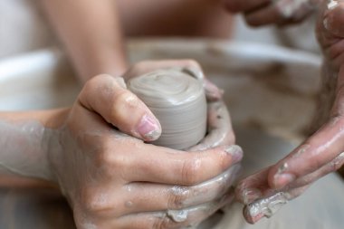 Polonya 'da modern sanat seramik atölyesinde atölye çalışması sırasında çömlekçi çarkında çamur tenceresi yapmak
