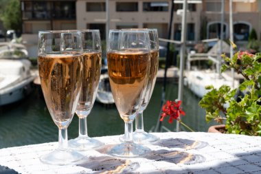 Fransız brut şampanyası şampanya köpüklü lale kadehleri ile Saint-Tropez yakınlarındaki Port Grimaud limanında, Fransız Riviera tatili, Var, Fransa yaz tatili