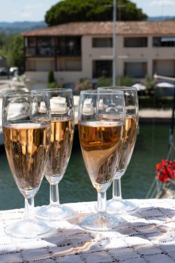 Fransız brut şampanyası şampanya köpüklü lale kadehleri ile Saint-Tropez yakınlarındaki Port Grimaud limanında, Fransız Riviera tatili, Var, Fransa yaz tatili