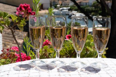 Fransız brut şampanyası şampanya köpüklü lale kadehleri ile Saint-Tropez yakınlarındaki Port Grimaud limanında, Fransız Riviera tatili, Var, Fransa yaz tatili