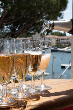 Fransız brut şampanyası şampanya köpüklü lale kadehleri ile Saint-Tropez yakınlarındaki Port Grimaud limanında, Fransız Riviera tatili, Var, Fransa yaz tatili