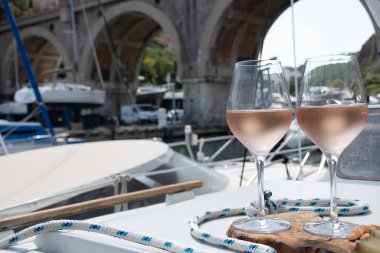 Party with cold rose wine on yacht boat anchored in port la Rague, Gulf of La Napoule, in Provence, two glasses of cold rose wine, French Riviera near Cannes, south of France clipart