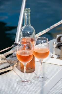 Party with cold rose wine on yacht boat anchored in port la Rague, Gulf of La Napoule, in Provence, two glasses of cold rose wine, French Riviera near Cannes, south of France clipart