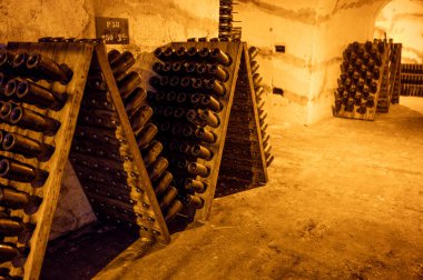 Şampanya şişeleri derin ve uzun yeraltı mağaralarında bulmaca raflarında, geleneksel yöntemlerle Reims, Champagne, France 'da şampanya yapmak.