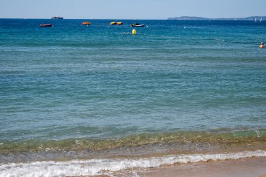 Cavalaire-sur-Mer ve La Croix-Valmer yakınlarındaki Plage du Debarquement beyaz kumlu sahilinde kristal berrak mavi su ve tekneler üzerinde sabah manzarası, Fransız Riviera, Var, Fransa 'da yaz tatili