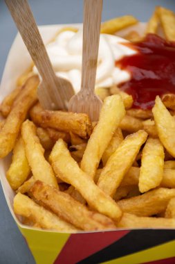 Belçika sokağı ve fast food, Belçika bayrağı renginde kağıt külah patates cipsi ve mayonez sosu.