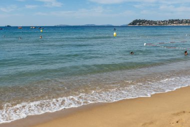 Cavalaire-sur-Mer ve La Croix-Valmer yakınlarındaki Plage du Debarquement beyaz kumlu sahilinde kristal berrak mavi su ve tekneler üzerinde sabah manzarası, Fransız Riviera, Var, Fransa 'da yaz tatili