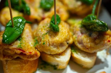 Bask ülkesinin tipik aperatifleri, küçük ekmek parçaları, balık, deniz ürünü, San Sebastian 'da veya İspanya' da Bilbao 'da servis edilen tatlı yeşil biberli pinkholar ya da pinktolar.