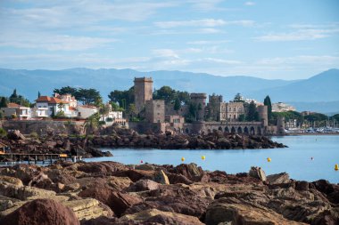 Yazın Fransa 'nın Fransız Rivierası, Cannes yakınlarındaki Mandelieu-la-napoule' da taşlı, hangarlı, şatolu sahil şeridi