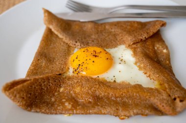 Brittany 'den karabuğday unundan yapılmış Galettes krepleri ve tuzlu malzemelerle servis edilen eritilmiş peynir ve yumurtalar.