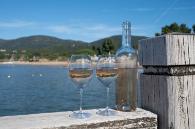 Provence 'den bir şişe soğuk gül şarabı ve beyaz kumlu plaj plajı Plage de Pampelonne, Saint-Tropez yakınlarında, Fransa' da yaz tatili, sahil kulübü partisi.