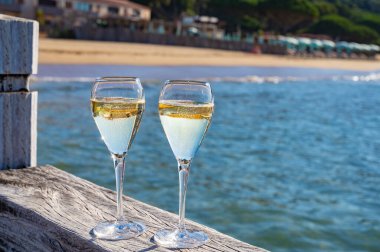 Provence 'de yaz mevsimi, iki bardak soğuk şampanya, krep şarabı güneşli bir günde Saint-Tropez yakınlarındaki ünlü Pampelonne beyaz kumlu plajda, Var Bölümü, Fransa, plaj kulübü partisi.