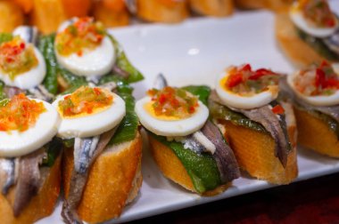 Bask ülkesinin tipik aperatifleri, küçük ekmek parçaları, deniz ürünleri, yumurta, peynir, San-Sebastian veya Bilbao, İspanya 'daki barlarda servis edilen jamon şişleriyle kapatılıyor.