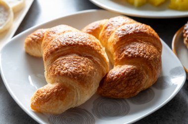 Taze pişmiş iki tereyağlı kruvasan restoranda servis ediliyor.