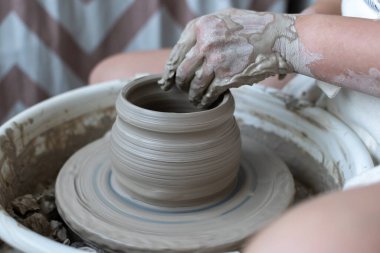 Polonya 'da modern sanat seramik atölyesinde atölye çalışması sırasında çömlekçi çarkında çamur tenceresi yapmak