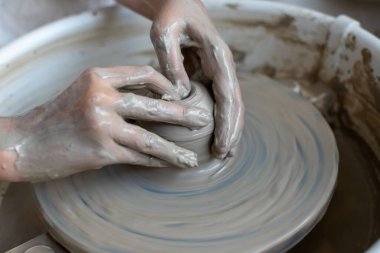 Polonya 'da modern sanat seramik atölyesinde atölye çalışması sırasında çömlekçi çarkında çamur tenceresi yapmak