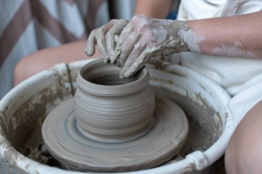 Polonya 'da modern sanat seramik atölyesinde atölye çalışması sırasında çömlekçi çarkında çamur tenceresi yapmak
