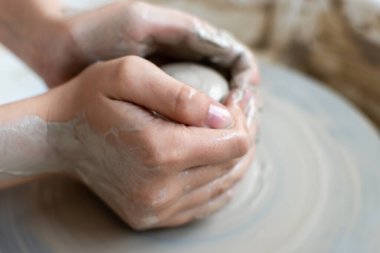 Polonya 'da modern sanat seramik atölyesinde atölye çalışması sırasında çömlekçi çarkında çamur tenceresi yapmak