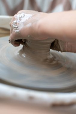 Polonya 'da modern sanat seramik atölyesinde atölye çalışması sırasında çömlekçi çarkında çamur tenceresi yapmak